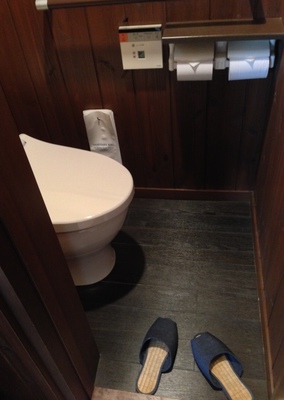 You're supposed to walk around your room in socks, but if you use the bathroom then use slippers.